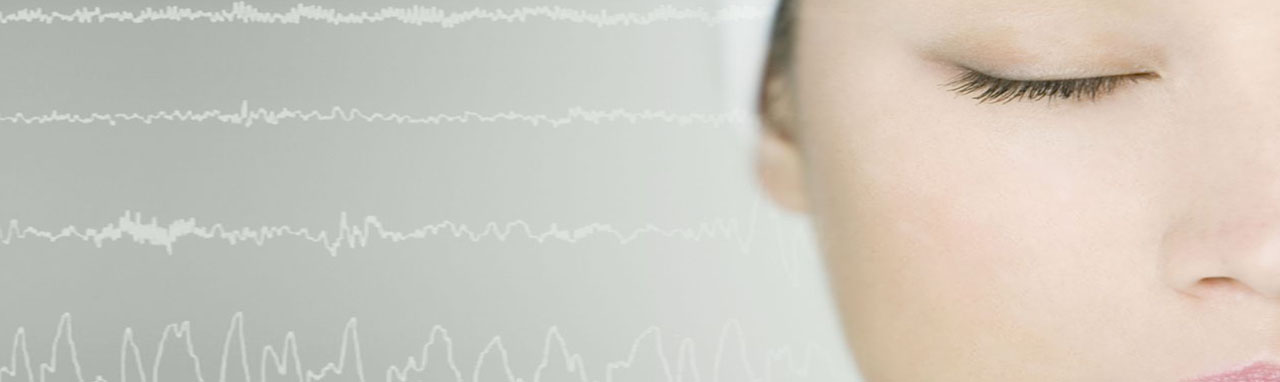 Gros plan sur le visage d'une femme les yeux fermés, sur la gauche une représentation d'un electro-encéphalogramme