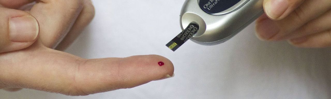 Gros plan sur le doigt d'une personne diabétique entrain de tester sa glycémie en prélevant une goutte de sang