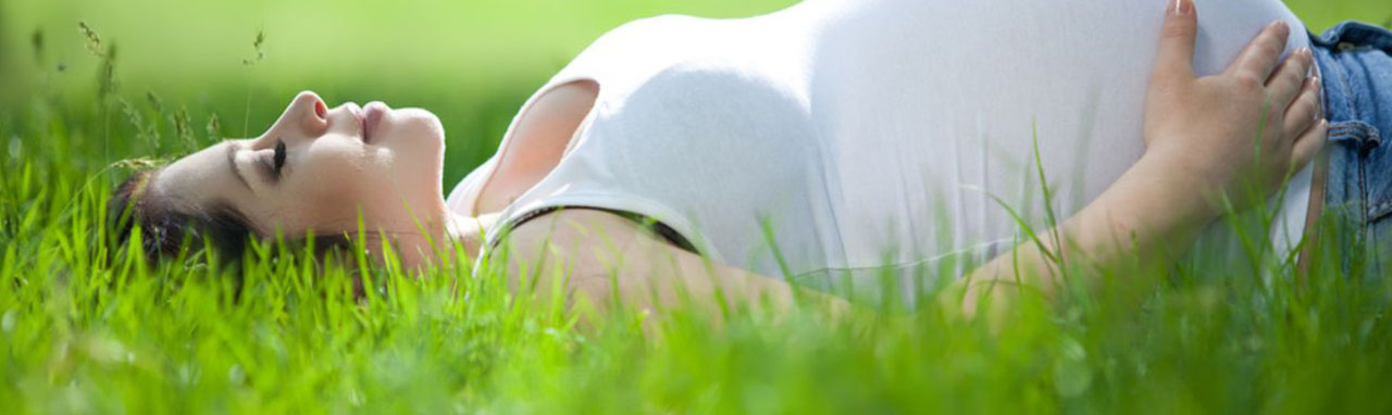 Une femme enceinte est allongée dans l'herbe