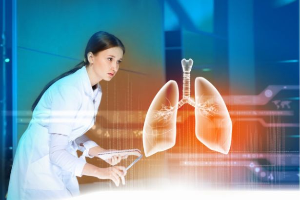 Une scientifique devant un bureau observe une paire de poumon modélisé en 3D