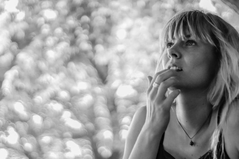 Photo en noir et blanc d'une femme pensive avec la main sur la bouche